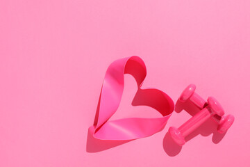 Dumbbells and fitness elastic band on pink background, flat lay. Space for text