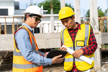 A team of construction engineers talks with managers and construction workers at the construction site. Quality inspection, plans, home and industrial building design projects