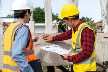 A team of construction engineers talks with managers and construction workers at the construction site. Quality inspection, plans, home and industrial building design projects