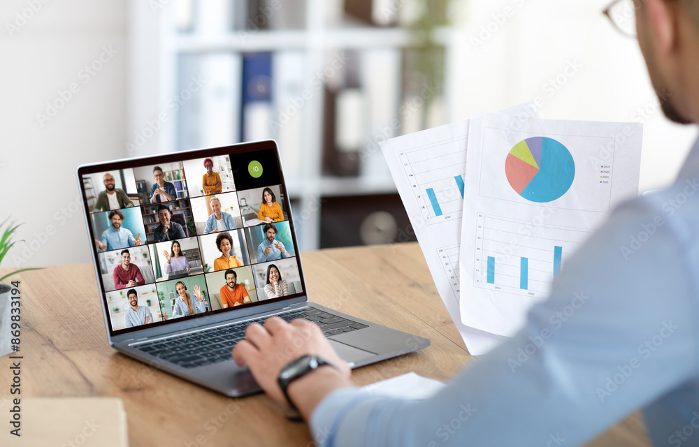 Poster a businessman sits at a desk in his office, using a laptop to participate in a virtual meeting with 