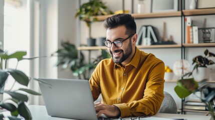 Handsome man working on a laptop in a well-organized home office, with a simple and clean background, dressed in casual business attire, highlighting the productivity and comfort of remote work 
