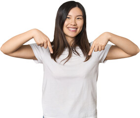 Fototapeta premium Young Chinese woman points down with fingers, positive feeling.