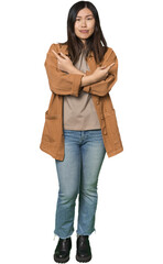 Fototapeta premium Full-body young Chinese woman points sideways, is trying to choose between two options.