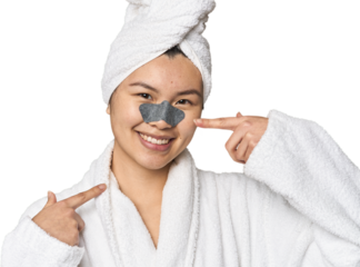 Chinese woman in robe with pore strip on nose in studio
