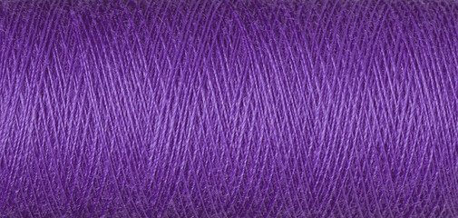 macro texture of a skein of purple sewing thread
