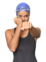 Fototapeta premium Pro Latina swimmer in studio gear throwing a punch, anger, fighting due to an argument, boxing.