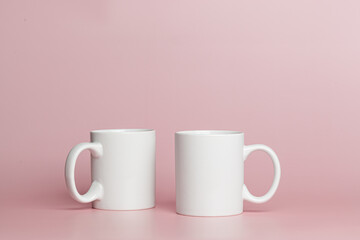 white cups for tea or coffee on a pink background