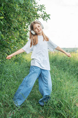 A child  with headphones listening to music and dancing