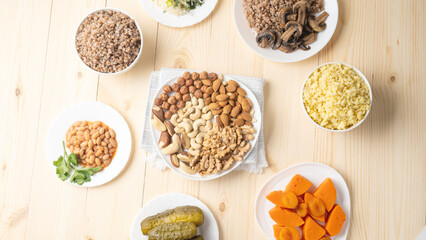 A table with a variety of foods including nuts, beans, and vegetables. The table is set for a meal.