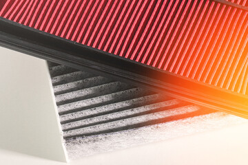 A black and white photo of a car's air filter and a white filter.