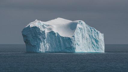 Antarctica Giant Iceberg Floating Against Gray Sky. Beautiful Blue and White Ice White Chunk Climate Change Global Warming View from Ship