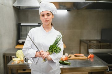 young beautiful female chef in kitchen