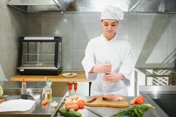 young beautiful female chef in kitchen