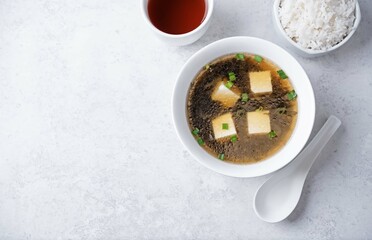 Seaweed soup with tofu and scallions in a bowl