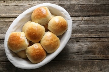 Delicious dough balls in basket on wooden table, top view. Space for text