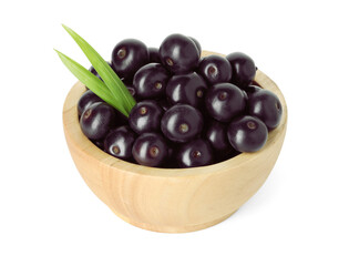 Fresh ripe acai berries in bowl and green leaves isolated on white