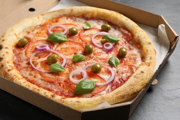 Delicious vegetarian pizza in box on black table, closeup