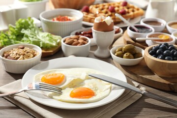 Different meals served for breakfast on wooden table