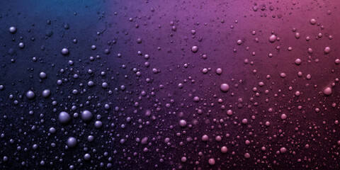 Fototapeta premium Perlende Farbtropfen: Ein faszinierendes Bild von zahllosen, schwebenden Tropfen in violett-blauen Farbtönen, die eine hypnotische und magische Atmosphäre auf einem dunklen Hintergrund schaffen
