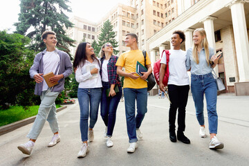 Obraz premium Free time of students. Friends walking after classes against university building