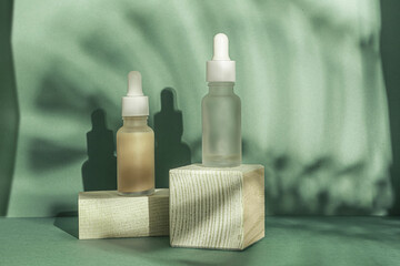 Cosmetic serum essence matte serum two bottle on green background with palm live shadow