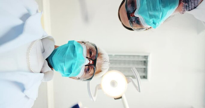 Pov, dentist and light for dental care in theater, healthcare or operating room for operation. Awake, anaesthesia or fail for surgery root canal, doctor or lamp for tooth extraction with orthodontist