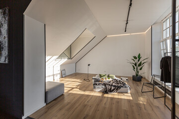 minimalist stylish interior of white simple bedroom with window in ceiling and sun rays without people