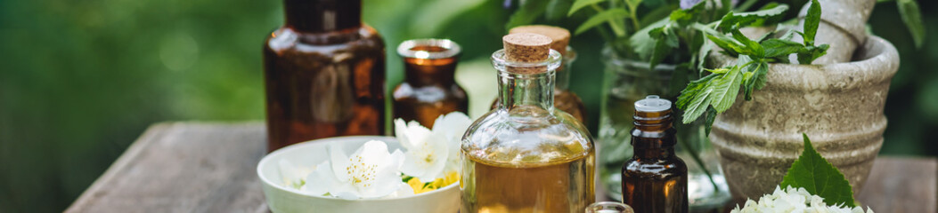 Concept of alternative herbal medicine. Bottles of tincture or potion, organic essential oils,...