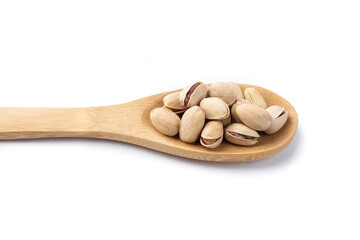 Salted roasted pistachios on a spoon isolated over white background