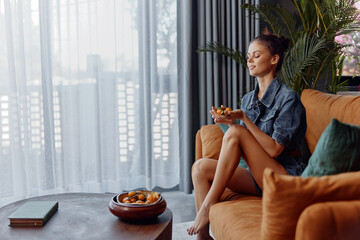 Woman enjoying a cozy home meal on a comfortable couch in a relaxed atmosphere