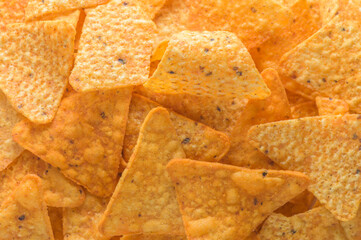 A pile of corn chips nachos covered in melted cheese