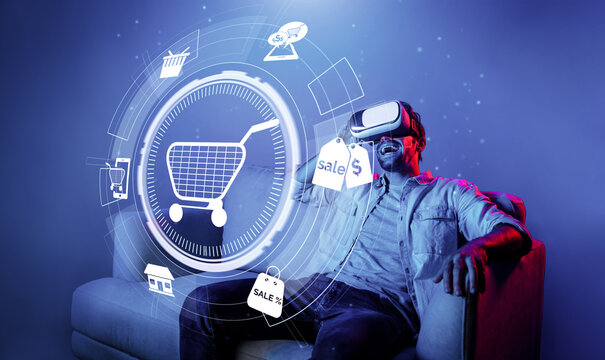 Happy man using VR headset and shopping online while sitting at sofa with shopping bags. Smart person looking at online market hologram and icon with neon background. Innovation technology. Deviation.