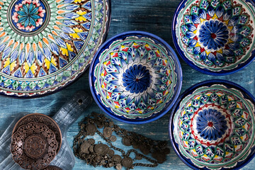 Asia ceramic tableware on blue background.  ceramic cups with traditional uzbekistan ornament.