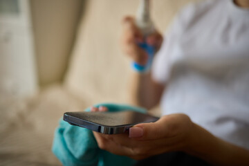 Obraz premium A person is using a microfiber cloth to clean their smartphone for hygiene purposes