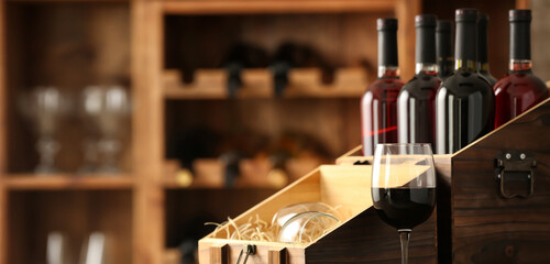 Box with bottles of wine on table in cellar