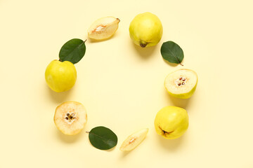 Frame made of sweet ripe quinces and leaves on yellow background