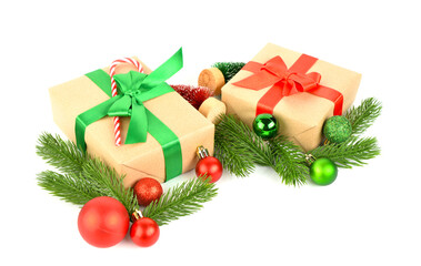 Gift boxes with Christmas tree branches, balls and candy cane on white background