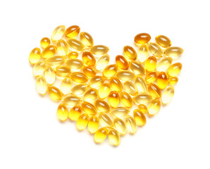 Heart made of fish oil capsules on white background
