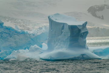 Incredible Antarctica Blue Iceberg in Ocean with Snow Covered Glacier Mountains in Background Elephant Island