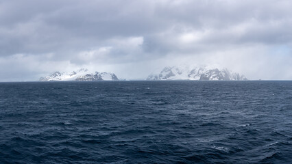 Antarctica Elephant Island in Distance Across Ocean. Dark Blue Water with Clouds Drama. Mountains...