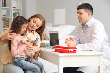 Little girl with inhaler and her mother in clinic