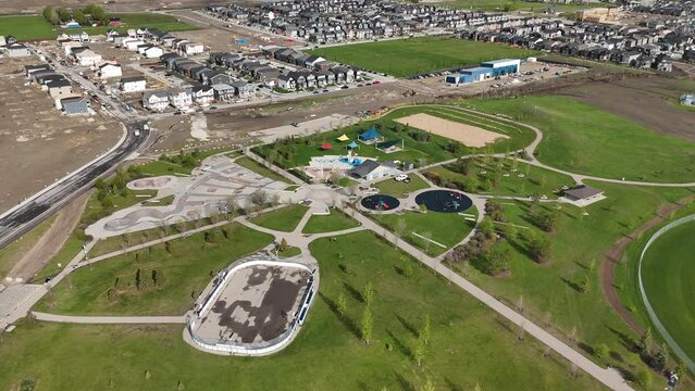 Aerial new home construction on city outskirts looking down on outdoor park space in Airdrie Alberta Canada.
