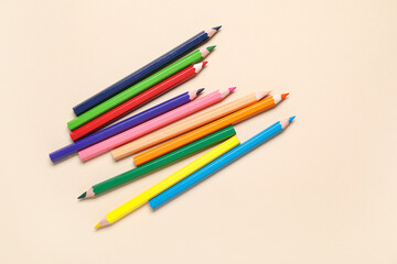 Colorful pencils on beige background