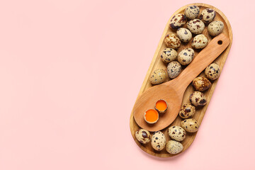 Wooden board and spoon with fresh quail eggs on pink background