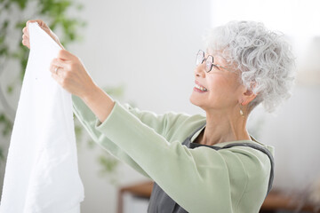汚れが落ちて洗濯が綺麗にできてタオルが気持ちいいシニア(高齢者)女性の横顔 © kapinon