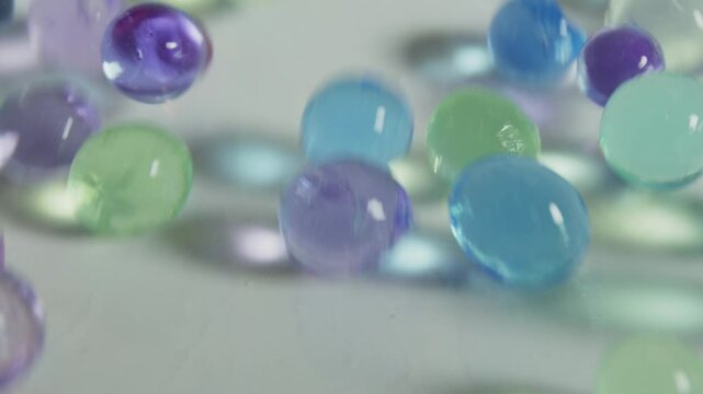 A bunch of colorful glass beads are scattered on a white surface. The beads are of various sizes and colors, creating a vibrant and lively scene. Concept of creativity and playfulness
