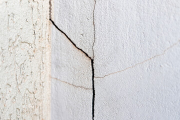Crack in the wall. Cracks can be caused by soil movement, inadequate structural load, climate variations, natural wear and tear and even construction errors.