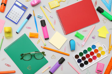 Eyeglasses and different stationery on grey background