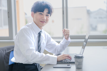 PCとガッツポーズするビジネスマン
