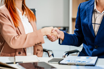 Young Asian businesswoman and businessman work together at desks, focusing on policy and planning analysis and various financial roles, emphasizing teamwork and professional collaboration.